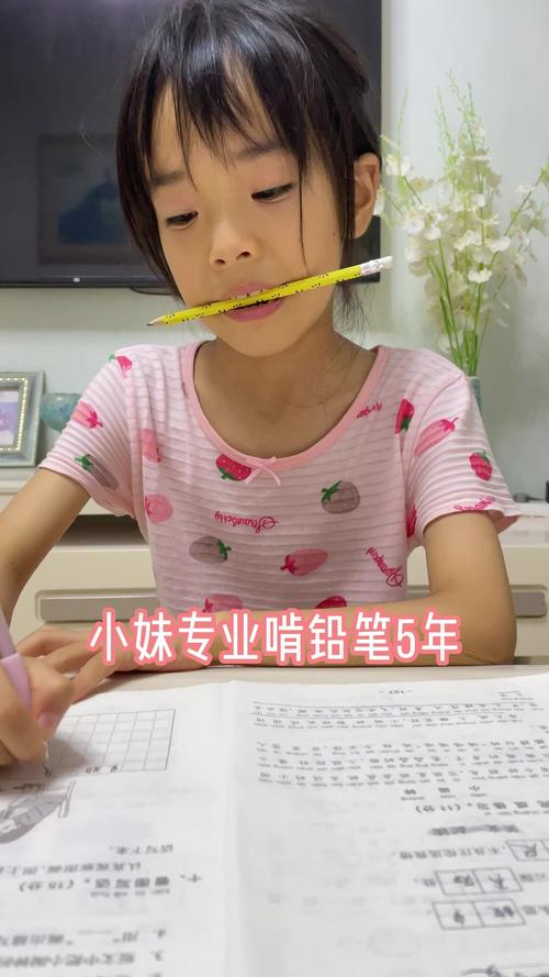 小学三年级学生对着作业本皱眉头咬铅笔