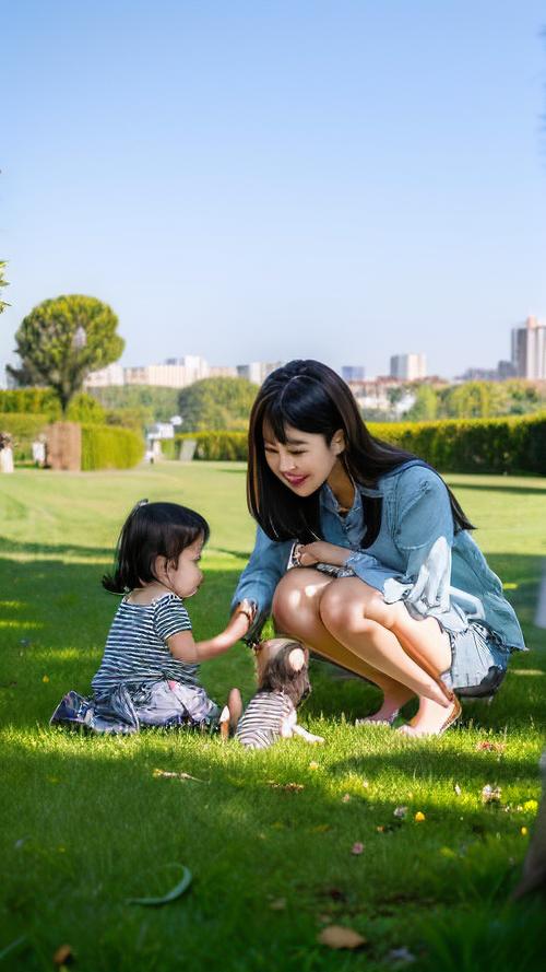 妈妈与孩子户外草地上随意玩耍的松弛育儿场景