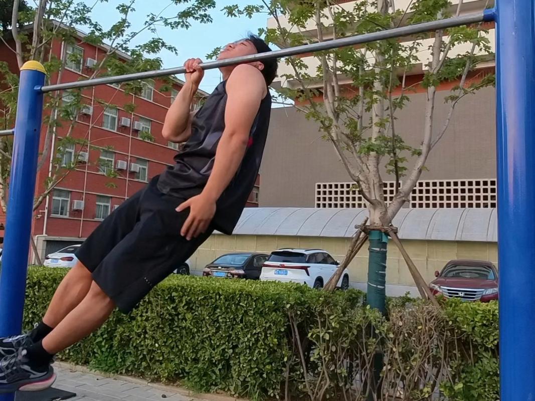 初中男生在单杠上挣扎做引体向上的瞬间