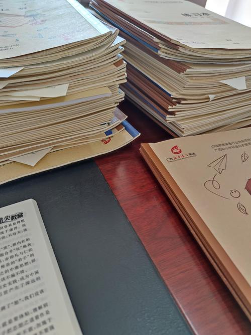 教师办公桌面堆着未批改作业和各类表格