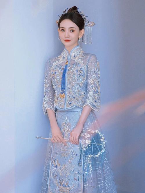 新娘手持银蓝色钉珠团扇搭配月白秀禾服婚礼写真