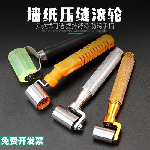 工人用刮板和压轮处理墙纸接缝
