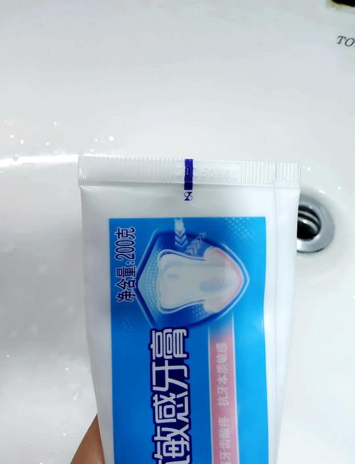 卫生间洗手台挤出凹痕的蓝色牙膏管