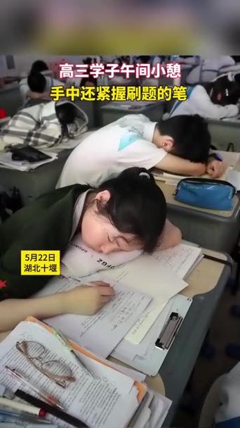晚自修教室学生趴在课桌前盯着物理试卷发呆的实拍
