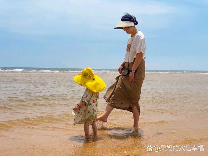 家长带孩子在沙滩聊天观察场景图