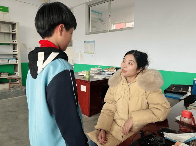校园走廊教师蹲身倾听学生聊天场景