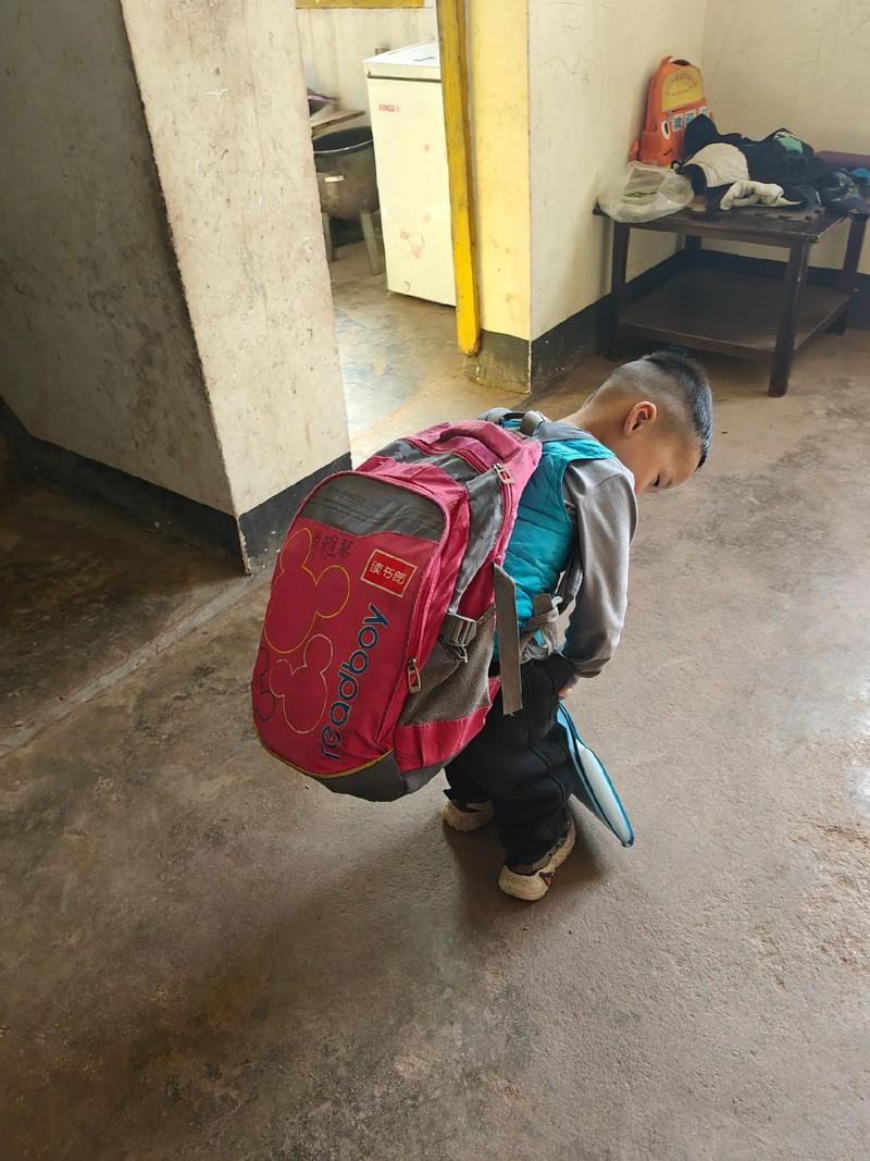 小男孩躺在地上不肯上学 书包扔在一边
