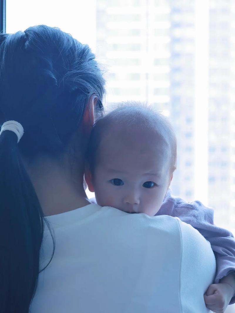 8月龄宝宝趴在妈妈肩头躲陌生人的实拍