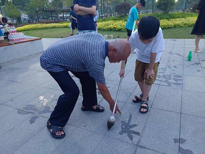 老爷爷公园写地书儿童蹲旁边临摹场景