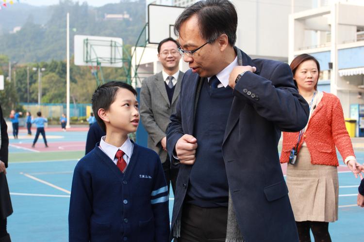 小学走廊上给学生塞砂糖橘的便装校长