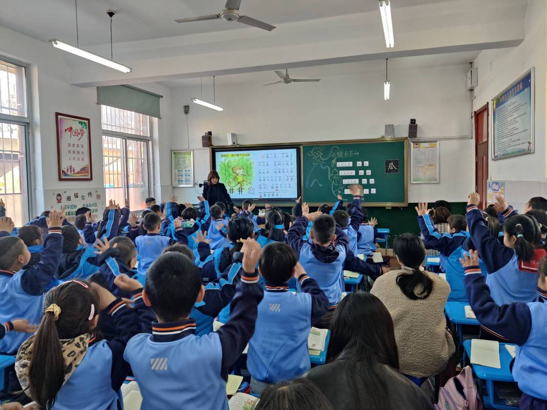 公开课上老师举着话筒等待学生集体齐答的实拍