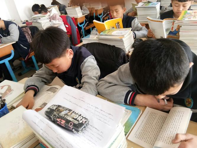 初中教室后排学生把小说压在练习册下刷手机