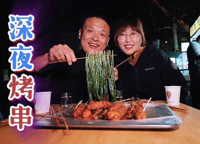 年轻夫妻在路边烤串摊说笑吃东西