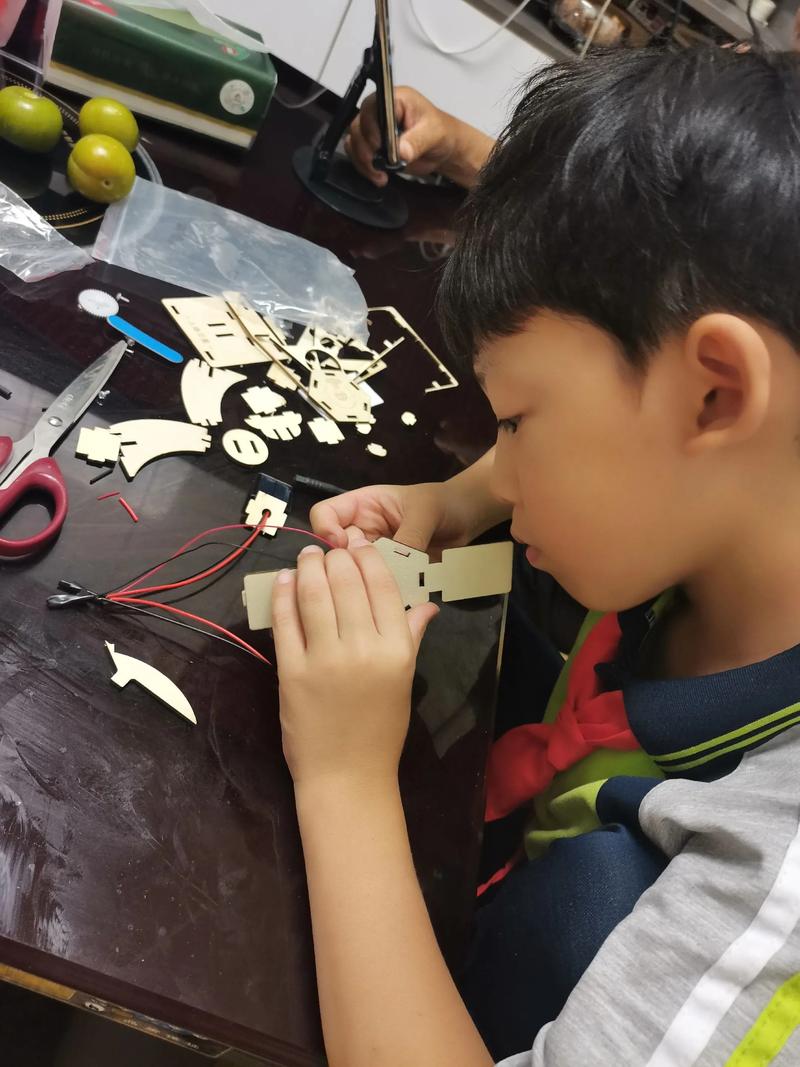 妈妈放下手机专注看着孩子的手工作品