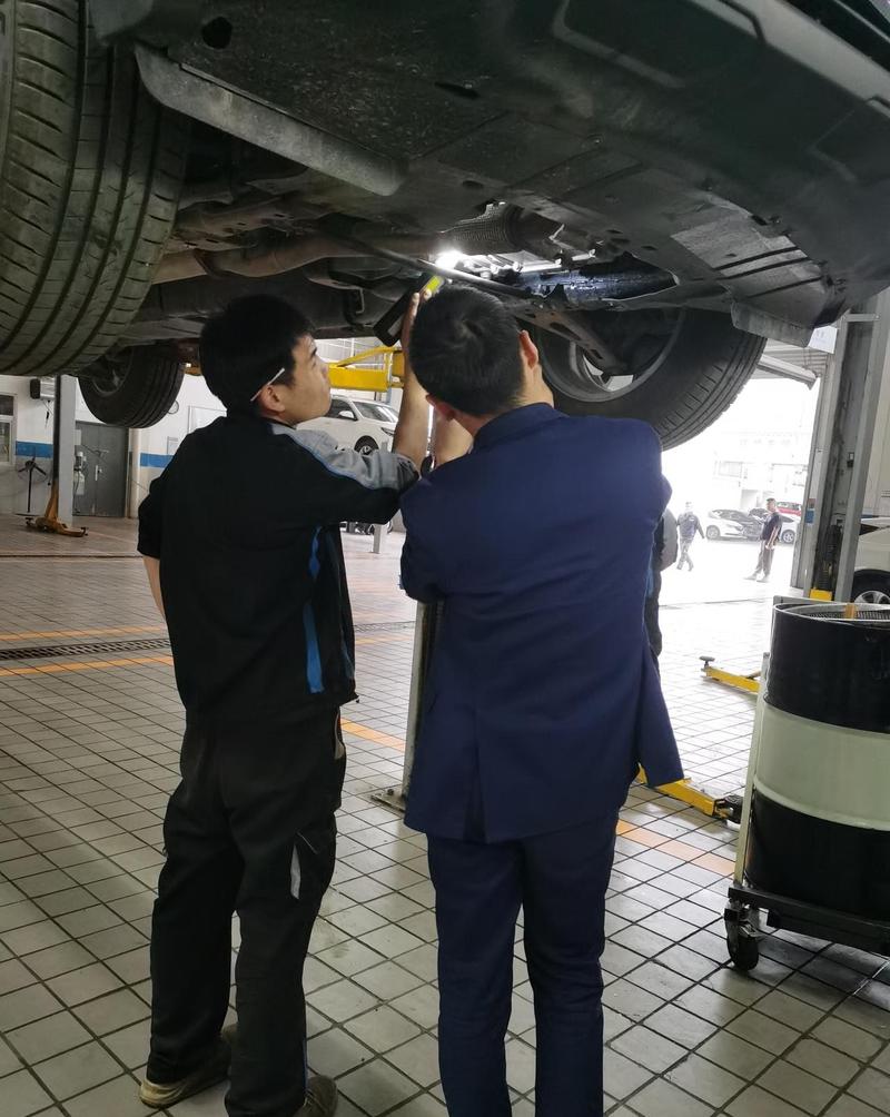 汽修师傅举升车辆检查自动变速箱油底壳渗漏