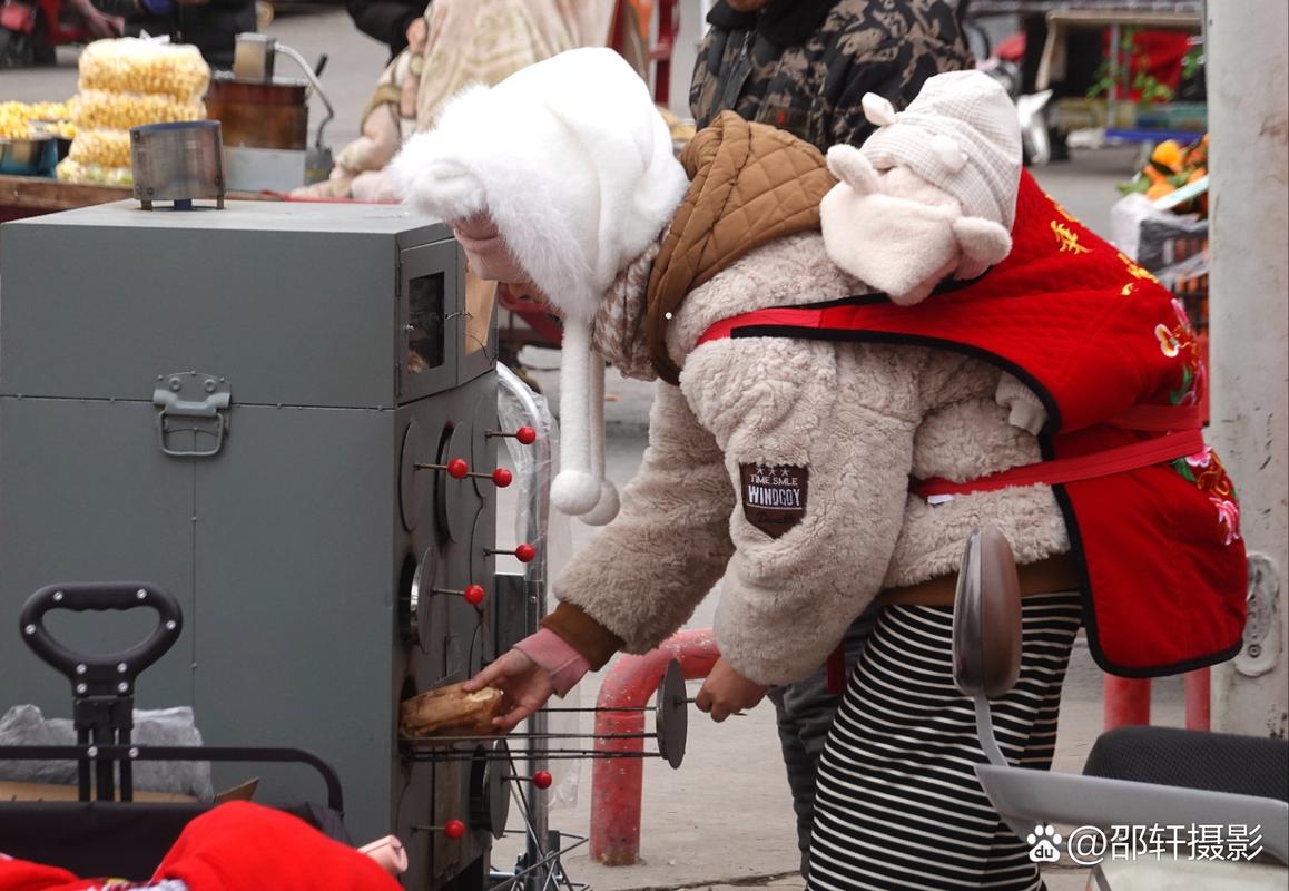 小区冬日路边烤红薯炉蹲守的小女孩背影