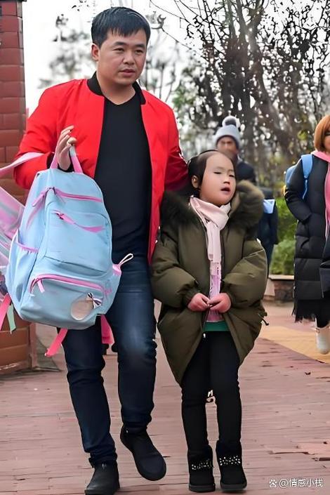 制造业年轻父亲下班穿工装在厂门口接六岁女儿放学的实拍图
