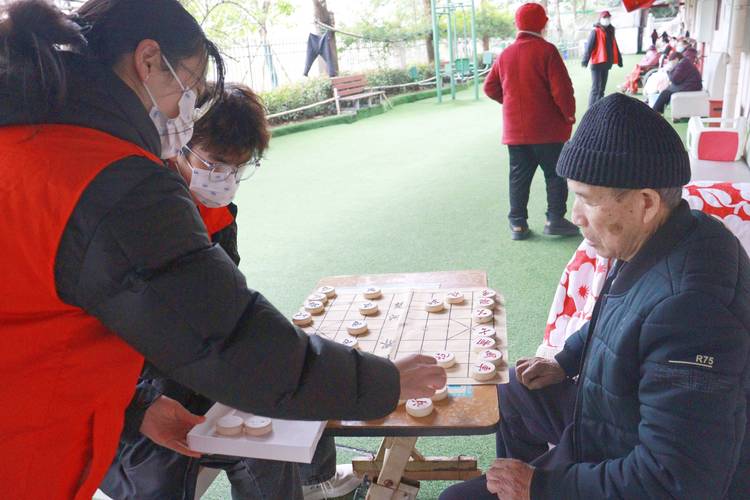 青少年志愿者在敬老院与老人下棋聊天