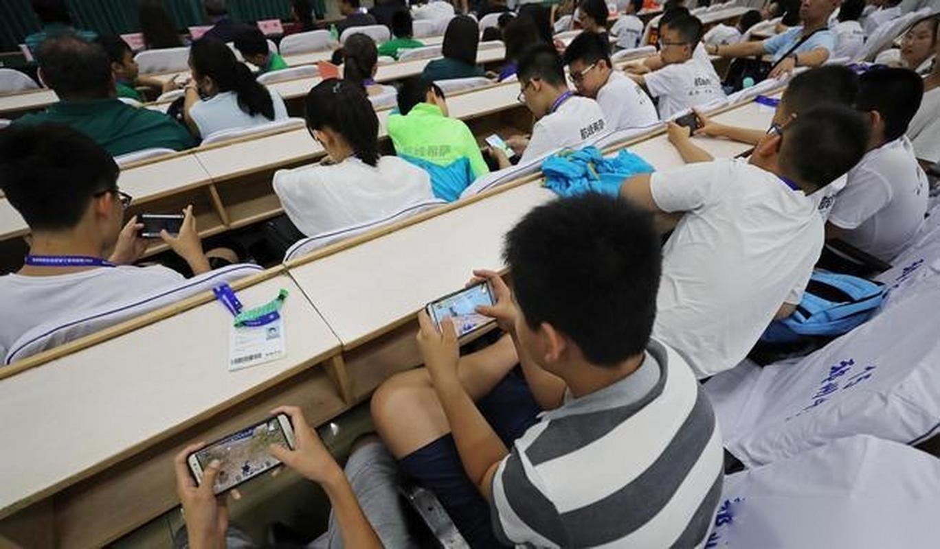 中学教室中学生围看手机短视频场景