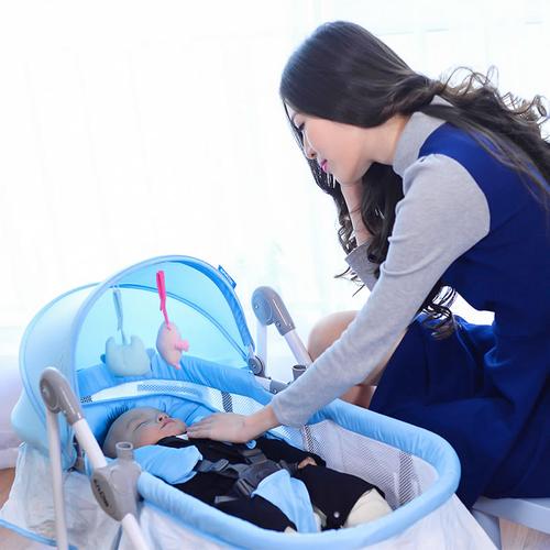 妈妈用摇椅安抚哭闹婴儿的温馨场景