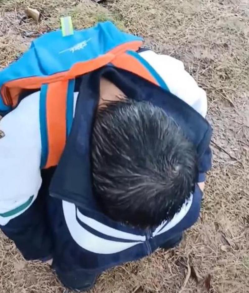 五岁男童因为赛跑输了蹲在草坪上掉眼泪的实拍图