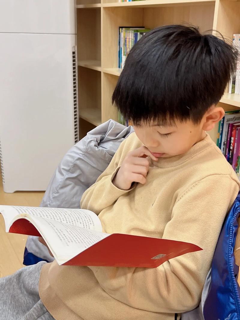 孩子皱着眉头认真阅读纸质书特写