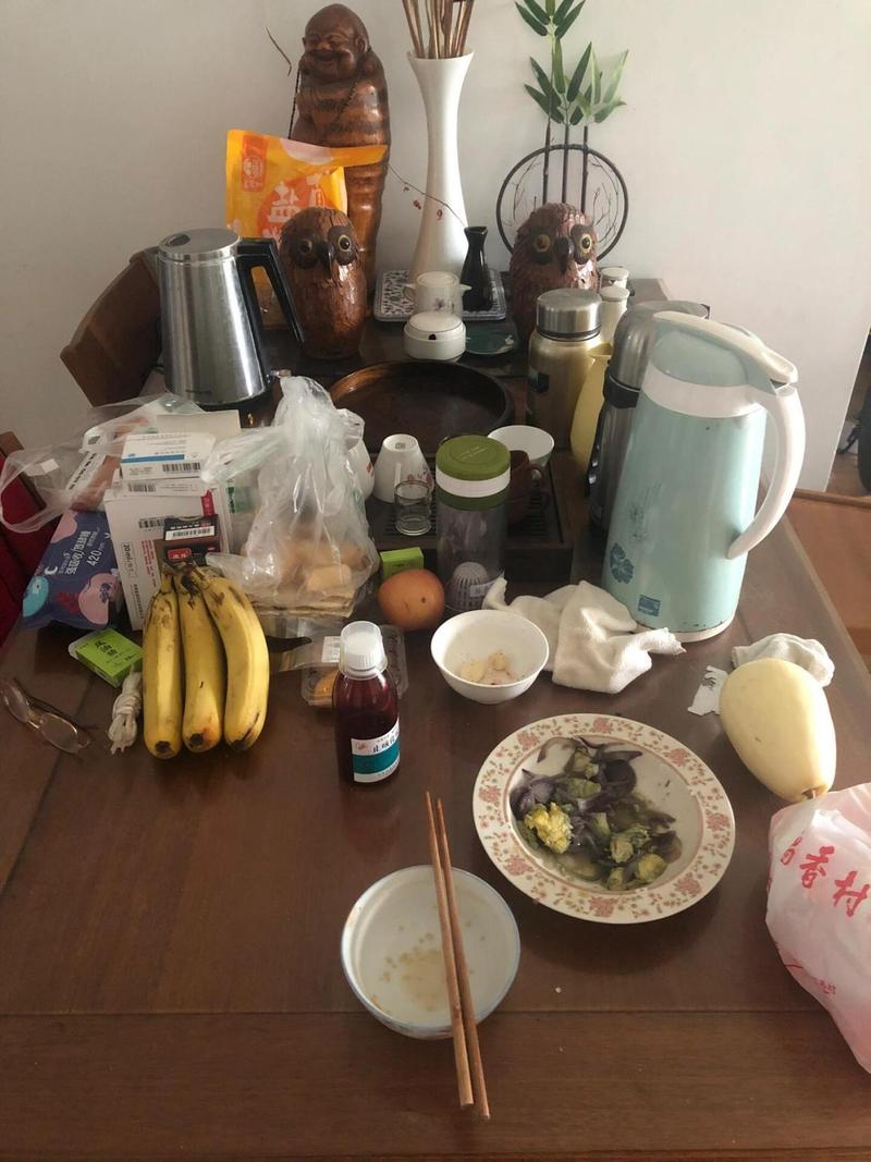 出租屋餐桌上堆满杂物的日常场景