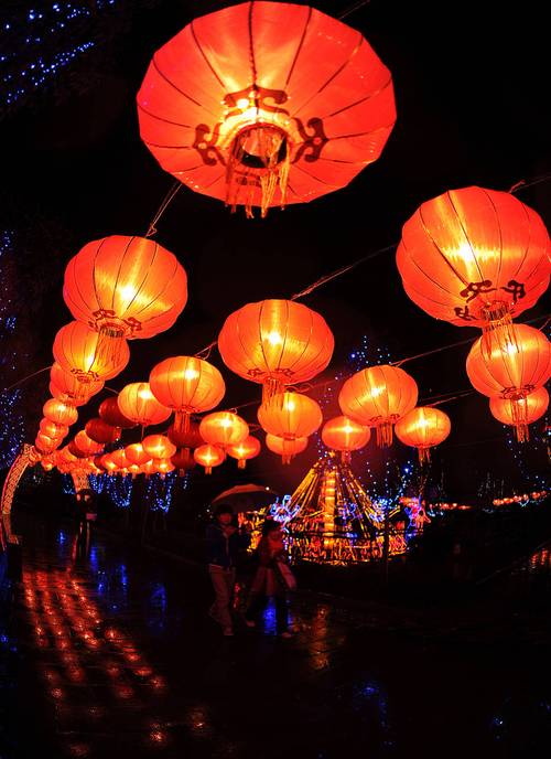 元宵节夜晚街头行人提着纸灯笼的画面