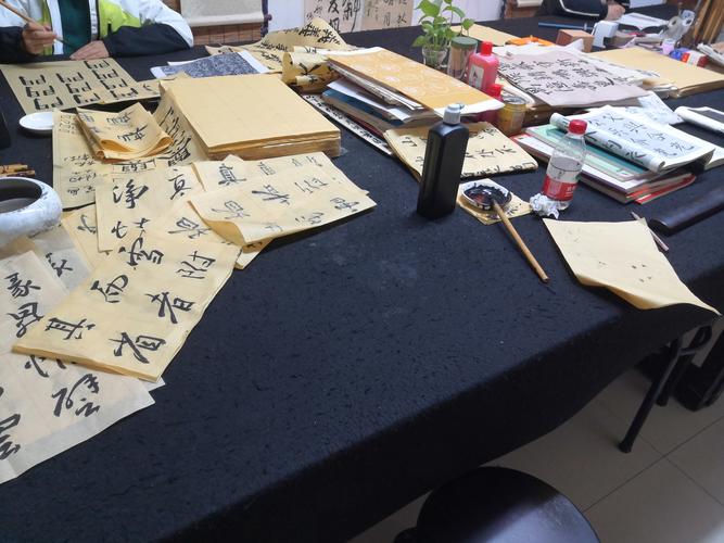 书法初学者杂乱书桌堆满字帖和毛笔