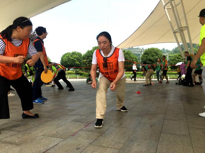 工厂职工妈妈下班后陪娃在厂区操场玩飞镖