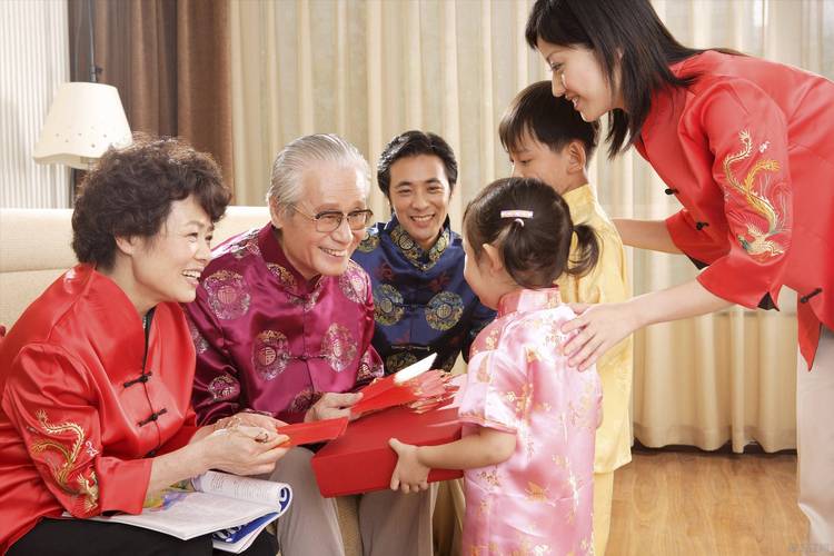子女陪长辈拆节日礼物温馨场景