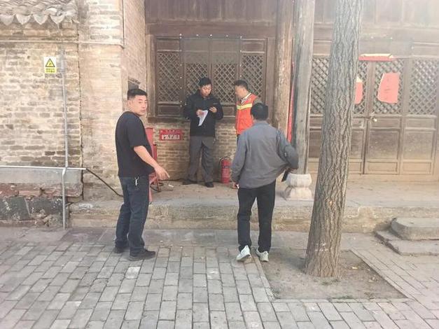 2026年9月北京胡同文物保护志愿者蹲在老城砖墙边记录残损情况