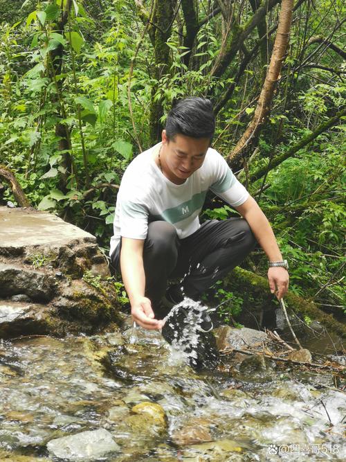 徒步者蹲在溪流边观察水面水黾的特写镜头