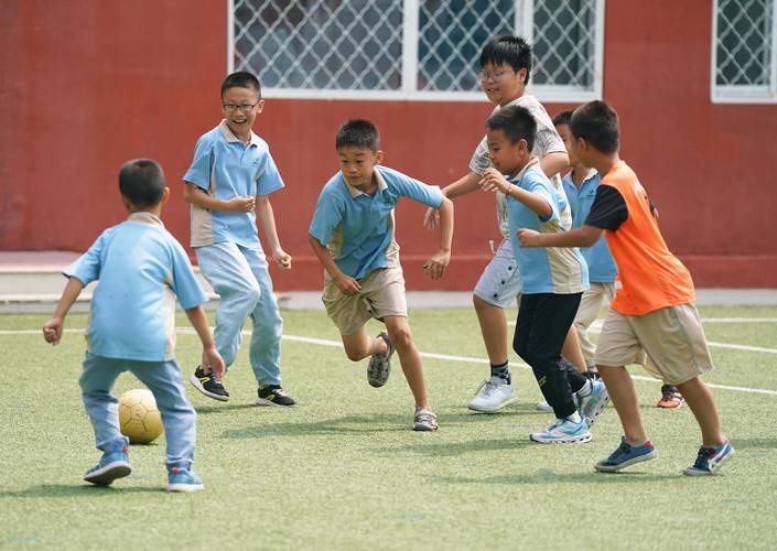 小学操场孩子们踢足球疯跑场景