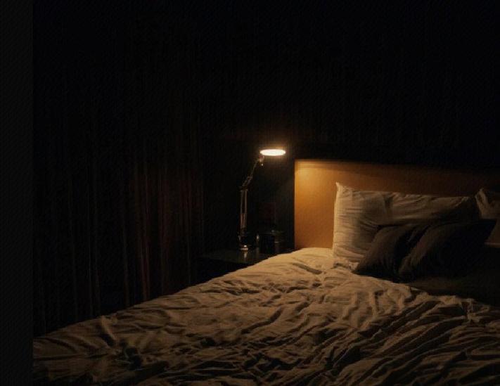 新手妈妈深夜卧室床头开小夜灯场景
