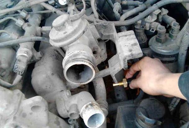 汽修工测量汽车水温传感器电阻操作图