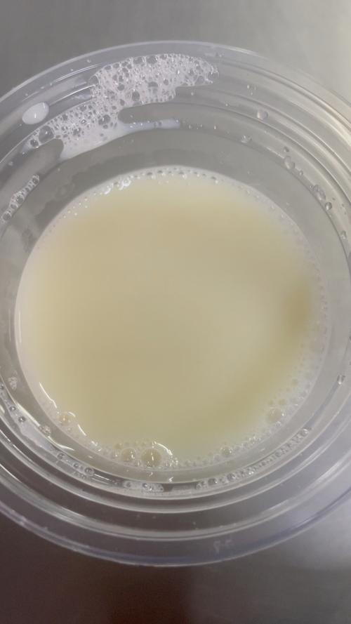 玻璃杯中牛奶表面有结皮和气泡
