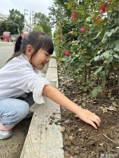两个小孩蹲小区花坛泥土上划汉字