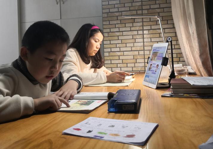 暖光书桌前家长和孩子一起核对数学练习册的日常场景