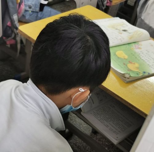 中学教室后排低头沉默男生