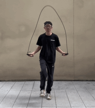 户外水泥地上一个人跳绳的动态抓拍