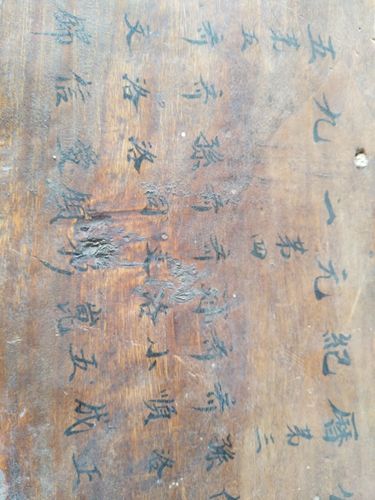 侗族风雨桥廊柱上被桐油浸成深褐色的赶圩人浅刻字迹