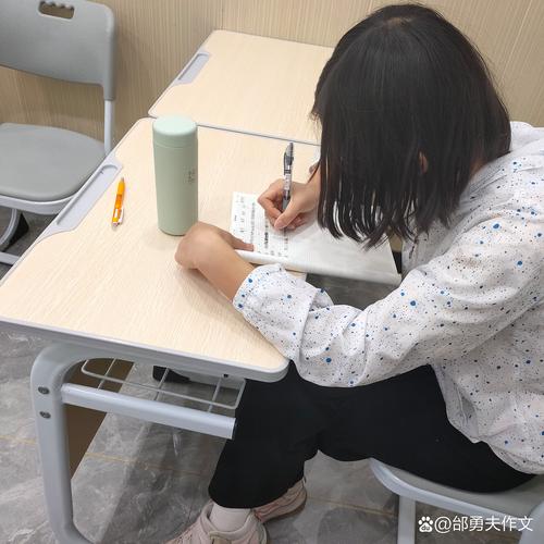 初中写作课上学生对着空白作文本咬笔的实拍