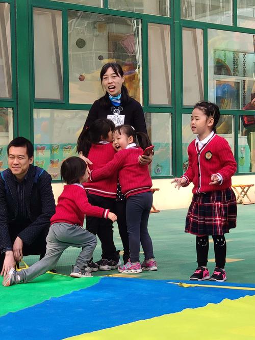 幼儿园老师在户外带领孩子做游戏，普惠园日常
