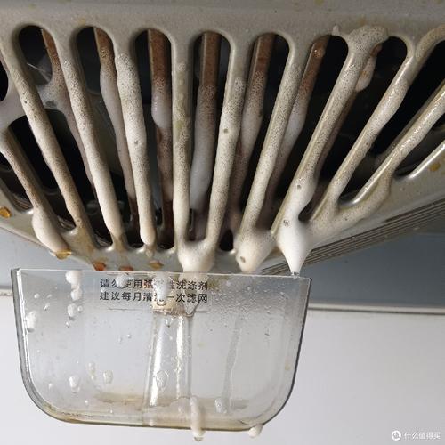 拆下来的抽油烟机滤网泡在加了食用碱的热水盆里