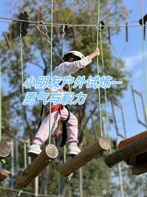 户外儿童攀爬架上女孩咬着牙向上攀登