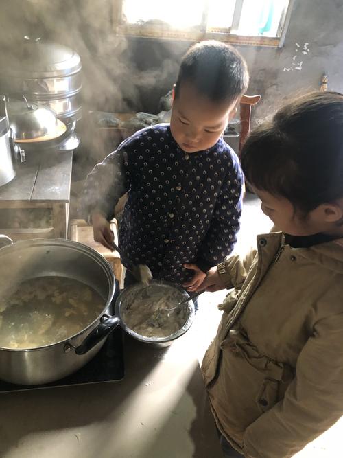 奶奶厨房给孩子盛炒米粥家常场景
