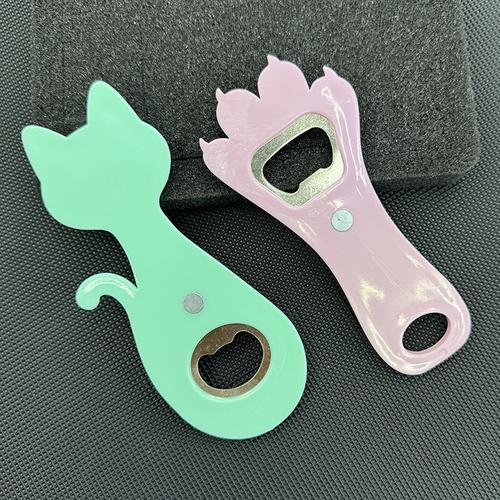 浅色冰箱门上吸着的藏青色猫咪开瓶器