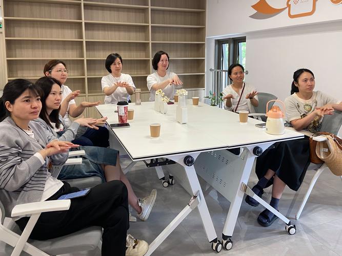 几位家长坐在社区咖啡馆交流育儿经验实拍