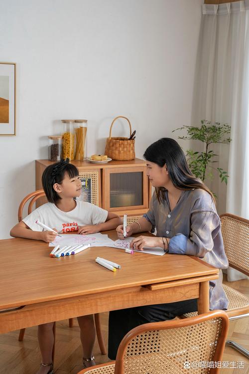 妈妈蹲在书桌边和闹脾气的初中生平视聊天的实拍